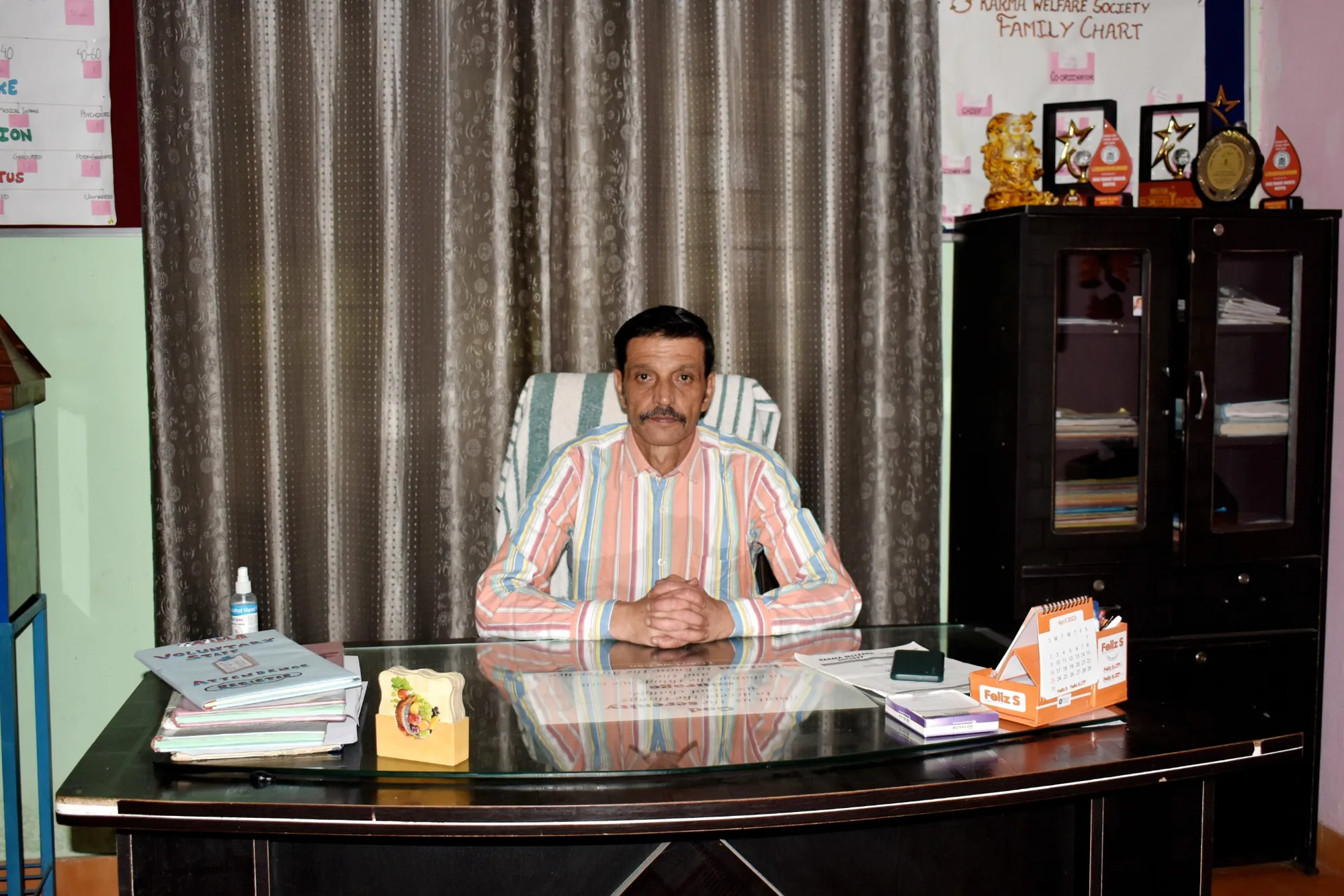 Ravinder Singh seated at his desk at Karma Welfare Society